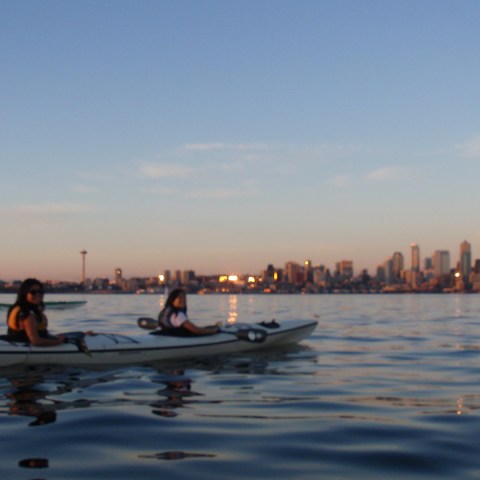 Tandam kayak with Seattle skyline at dusk