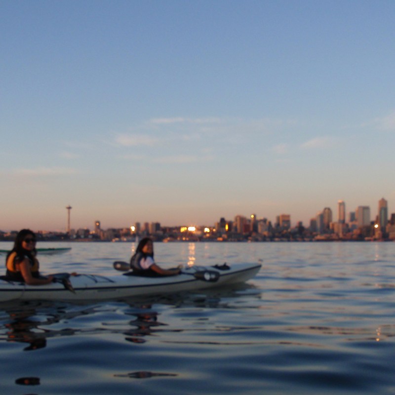 Tandam kayak with Seattle skyline at dusk