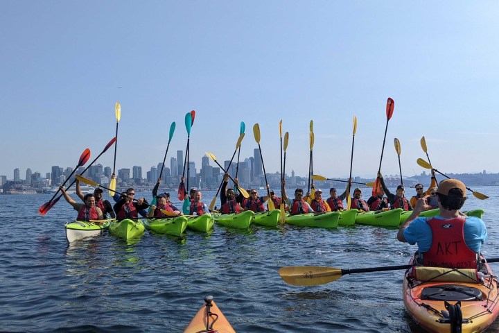 a group of people rowing a boat in the water