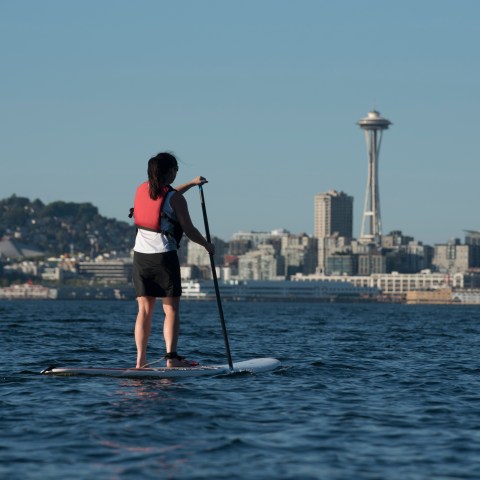 Woman on paddle board next to space needle