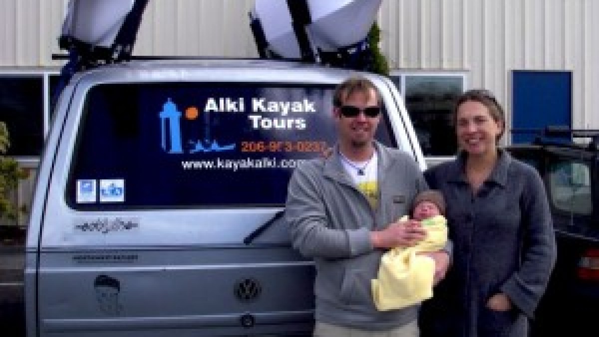 Man and woman with baby by a car
