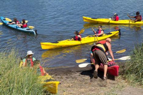 Man pushing kayak in to water